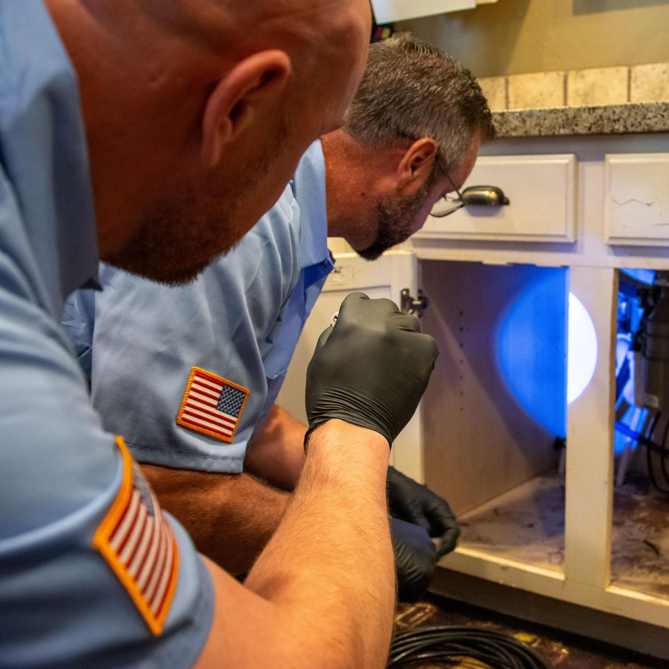 A plumber in Escondido holding a tool box in a residential neighborhood